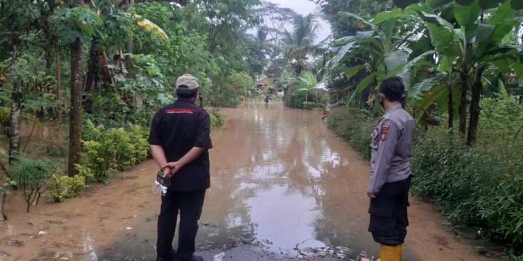 Jalan Kebanjiran, Kanit Binmas Polsek Sukaresik Bantu Sebrangkan Anak Sekolah